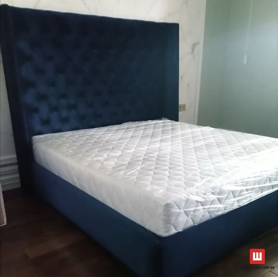 синяя мягкяа кровать с каретной стяжкой